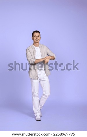 man in casual shirt posing on purple background.