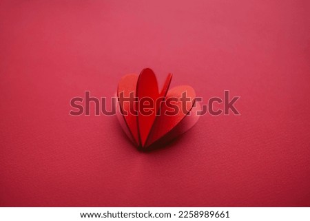 Handmade paper cutout heart for valentine's day on red background for your offer. 