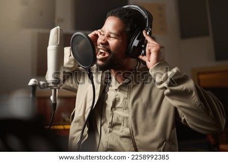 Music, streaming and man recording in studio in home, singing into microphone with headphones and talent. Technology, art and creative influencer or musician with live stream song for record label.