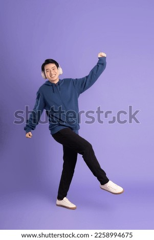 portrait of asian man posing on purple background