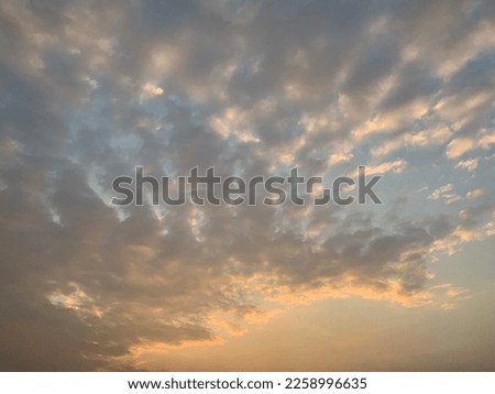Stratocumulus clouds background Pastel orange mix blue appear frequently in the atmosphere layered Gray in Bangkok, Thailand. no focus
