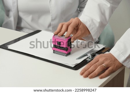 Sealing document to close a business.Notary stamp on the table, close-up