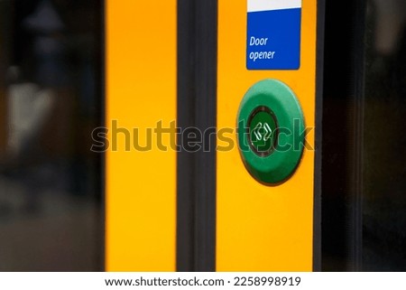 A close-up of an external button for opening doors in a tram.