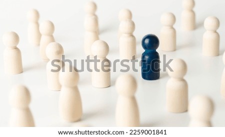 Wooden figures of people, one of them is blue. Concept of rare disease, LGBTQ, virus epidemic, spy, talent, leadership and unique. Royalty-Free Stock Photo #2259001841