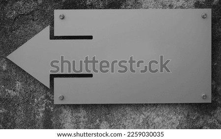 texture of the stone wall. grey plastic arrow. empty on grey plastic signboard. mockup. Pointer to the building. mock up.