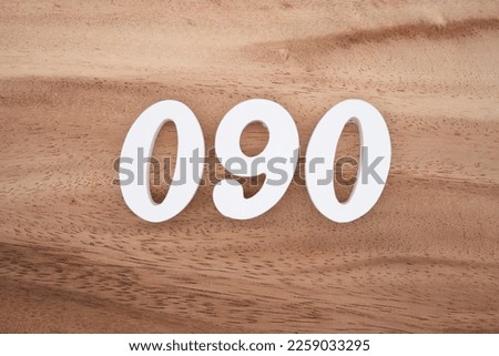 White number 090 on a brown and light brown wooden background.