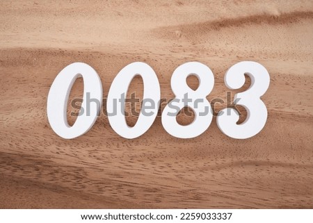 White number 0083 on a brown and light brown wooden background.