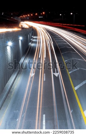 Long exposure of light reflected by headlights of cars on city road at night