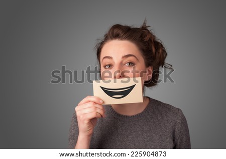 Happy pretty woman holding card with funny smiley on gradient background