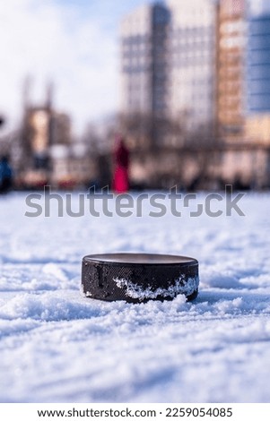 black hockey puck lies on ice at stadium