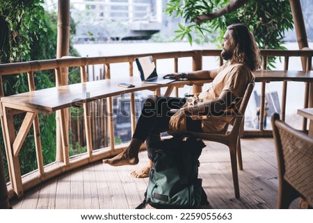 Skilled software developer editing data info via service application on modern laptop technology, millennial digital nomad with netbook checking content publication during web networking outdoors