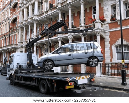 Lift truck removing illegally parked vehicle Royalty-Free Stock Photo #2259055981