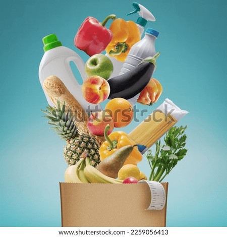Assorted fresh groceries falling in a paper bag, grocery shopping concept Royalty-Free Stock Photo #2259056413