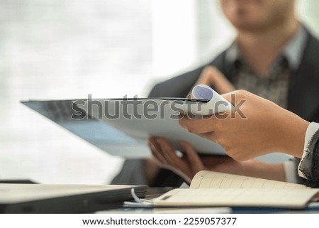 secretary present a document to boss to reading. coworker explain statistics, Hand finger point to drawing graph presentation explaining new idea for business improvement to teamwork. Royalty-Free Stock Photo #2259057377