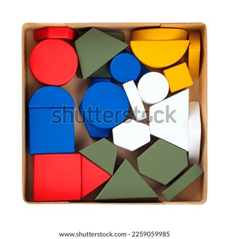 geometric figures made of wood, painted and stacked on a table in a box, isolated