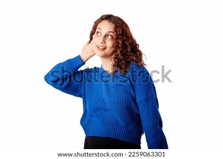 Portrait of cheerful woman wearing sweater standing isolated over white background smiling with hand over ear listening an hearing to rumor or gossip. Deafness concept. All ears and very curious.