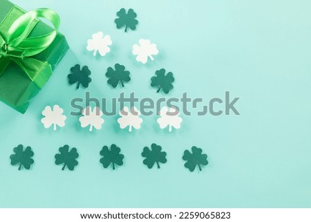 Happy St Patrick's Day decoration background concept. Top view gift box green clover leaves, shamrocks leaves holiday symbol with copy space on blue background
