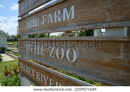 Close up Wooden Sign board of direction to the mini farm, little zoo, flower garden, secret river at Obelix village. Design of wooden board.  