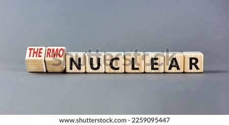 Nuclear or thermonuclear energy symbol. Concept words Nuclear or Thermonuclear on wooden cubes. Beautiful grey table grey background. Business Nuclear or thermonuclear concept. Copy space.