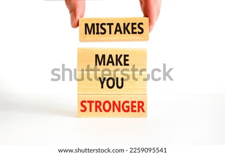Mistake make stronger symbol. Concept words Mistakes make you stronger on wooden blocks. Beautiful white background. Businessman hand. Business mistake make stronger concept. Copy space.