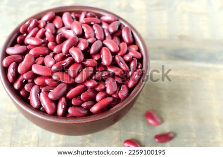 Red beans in a brown bowl on a wooden background. The concept of vegetarian food. Rustic style. Horizontal orientation. Copy space.