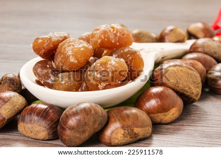 Chestnuts and marron glace over a light brown background Royalty-Free Stock Photo #225911578
