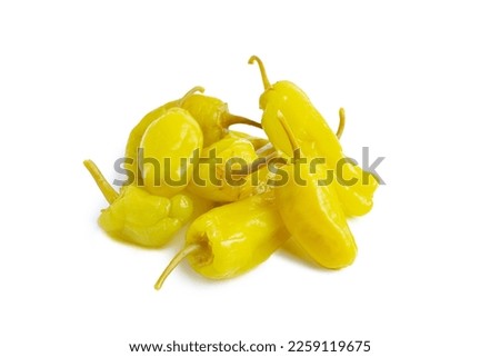 Pile of pickled yellow peppers, pepperoncini or friggitelli isolated on white background. Hot pepper marinated, brined. Traditional Italian and greek cuisine, ingredient for salad, pasta, sauce. Royalty-Free Stock Photo #2259119675