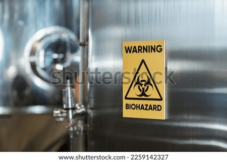 Close up of Warning biohazard sign on storage tank in chemical factory, copy space