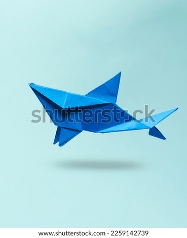 Origami shark levitating on a blue background