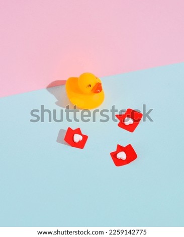 Rubber duck with Social media likes on pink background. Creative minimalist layout