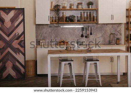 modern kitchen fragment with utensils, fruit, table and chairs closeup photo