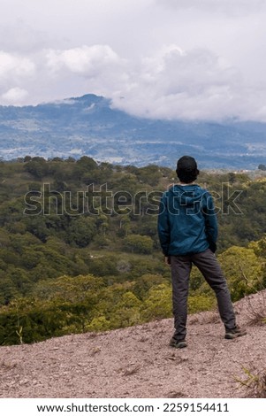 Young man enjoying the view of a beautiful landscape. Guavata, Santander. Royalty-Free Stock Photo #2259154411