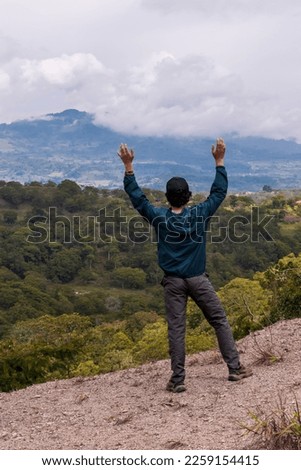 Young man enjoying the view of a beautiful landscape in the morning. Guavata, Santander. Royalty-Free Stock Photo #2259154415