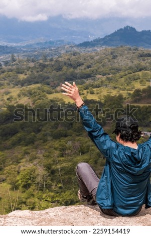Young man enjoying the view of a beautiful landscape in the morning. Guavata, Santander. Royalty-Free Stock Photo #2259154419