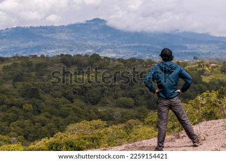 Young man enjoying the view of a beautiful landscape. Guavata, Santander. Royalty-Free Stock Photo #2259154421