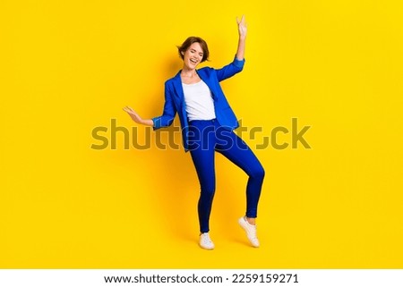 Full length photo of good mood cheerful lady dressed blue blazer smiling having fun isolated yellow color background