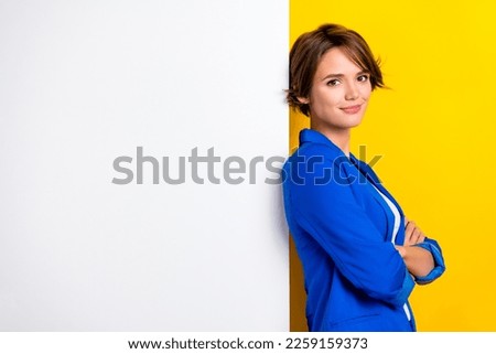Photo of pretty shiny lady dressed blue blazer arms folded white wall placard empty space isolated yellow color background