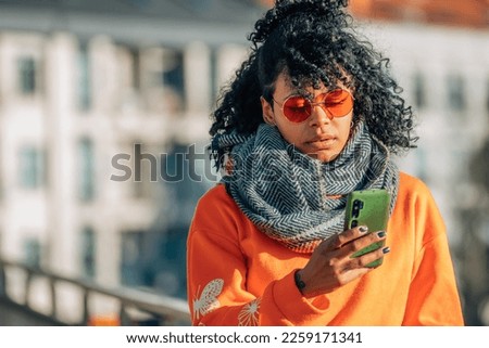 afro american girl in street with mobile phone