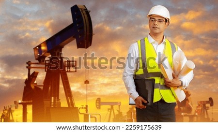 Man engineer of oil company. Builder near industrial landscape. Oil pumps during sunset. Builder designer oil producing station. Man engineer in protective helmet. Career in fuel industry