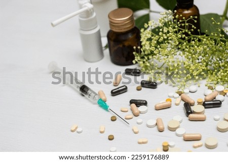 Variation of vitamins and pills on a green leaf on a white background