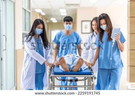 Group of professional medical doctor team and assistant with stethoscope in uniform taking seriously injured coma patient to operation emergency theatre room in hospital.health medical care concept Royalty-Free Stock Photo #2259191745
