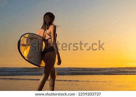 Girl surfer, vacation on Bali, Indonesia. Download a photo with copy space to advertise tours to a warm country. Surfing and vacation picture for social media promo.