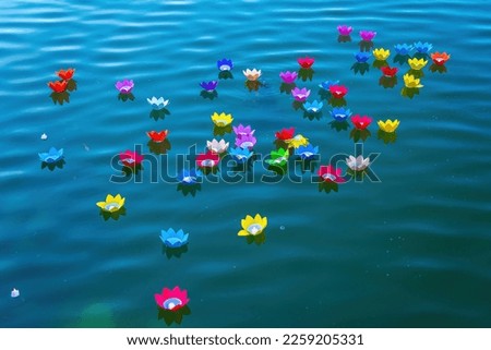 Floating colored lanterns and garlands and fish KOI on river at night on Vesak day day for celebrating Buddha's birthday, that made from paper and candle. Commemorating those who have passed away Royalty-Free Stock Photo #2259205331