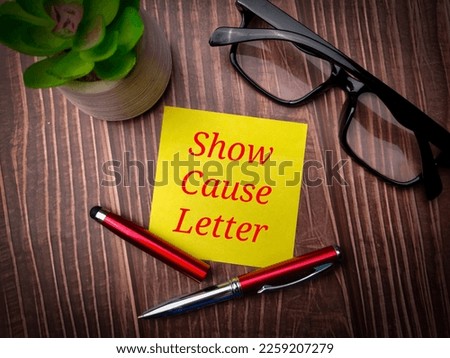 Pen and glasses with the word Show Cause Letter on wooden background.