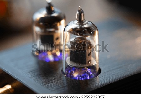 The tube sound, the valve sound. A vacuum tube in a socket of an audio device, with a glowing heater or filament. Shallow depth of field.
 Royalty-Free Stock Photo #2259222857