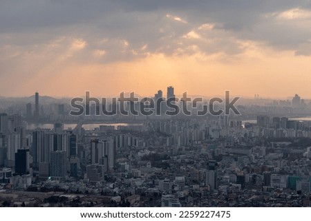 This is a picture of Seoul covered with dust and the sun covered by clouds as seen from Namsan Mountain at sunset.

