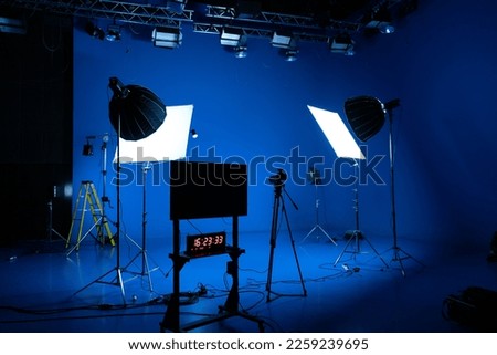 Professional video studio behind the scenes video footage behind the scenes silhouette production photography with focus on camera and studio equipment.