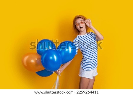 party girl with balloon in sunglasses. shocked girl hold party balloons in studio. girl with balloon