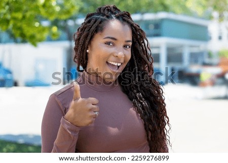Happy african american woman with braid outdoor in summer in city Royalty-Free Stock Photo #2259276899