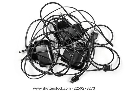 Chargers with tangled wires on a white background. Wired chargers for phones. Royalty-Free Stock Photo #2259278273